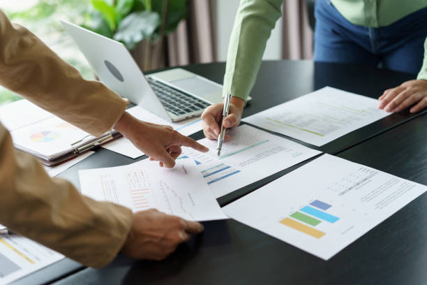 istock Team leader coach teach young workers explain on paper for business plan listen talkative coworker and discussing new project presentation Serious professional advisor consultingÂ in office. 2195409673