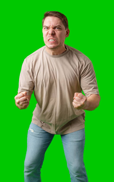 istock Man expressing intense frustration while standing against a bright green background 2195413171