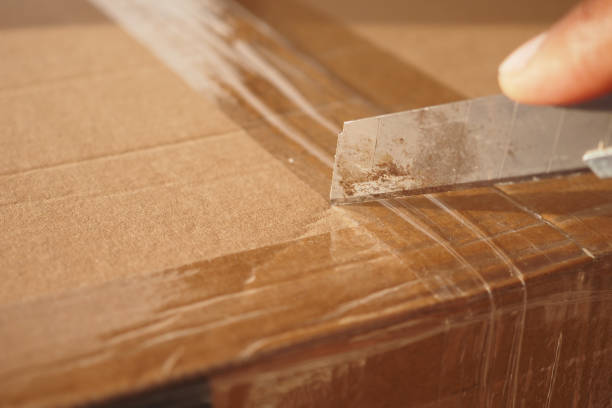 istock Carefully Opening a Package using a Utility Knife for Safe Unboxing and Extraction 2195414799