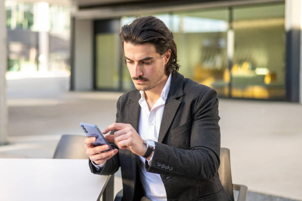 istock Successful Entrepreneur Interacting With Smartphone In Open Area. Professional Businessman Reviewing Client Agenda While Using Smartphone 2195416487