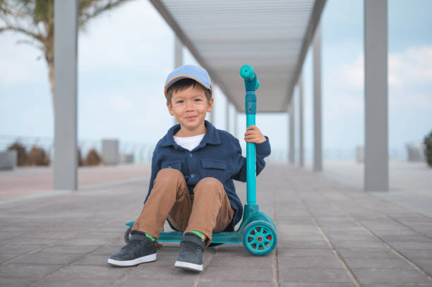 istock Child Sitting on Scooter with Happy Expression 2195417212