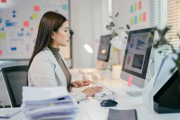 istock Professional businesswoman focusing on data analysis, working intently at computer in contemporary workspace, demonstrating concentration and corporate expertise 2195417485
