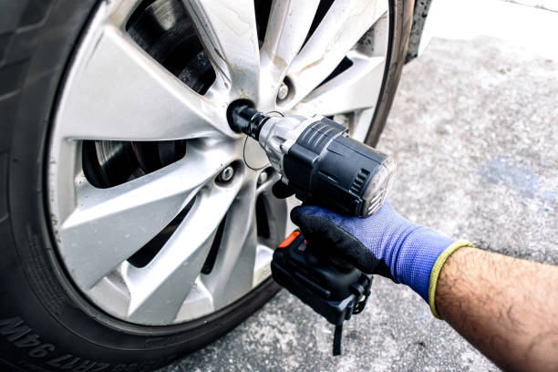 istock Auto mechanic using impact wrench cordless to change car wheel 2195418275