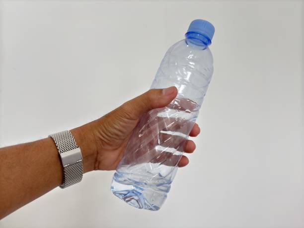 istock Close up hand holding empty plastic water bottle on white background 2195420128