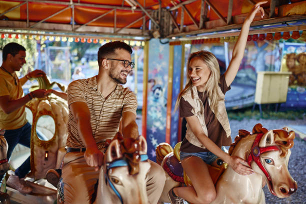 istock Carefree couple having fun during a ride at amusement park. 2195420278