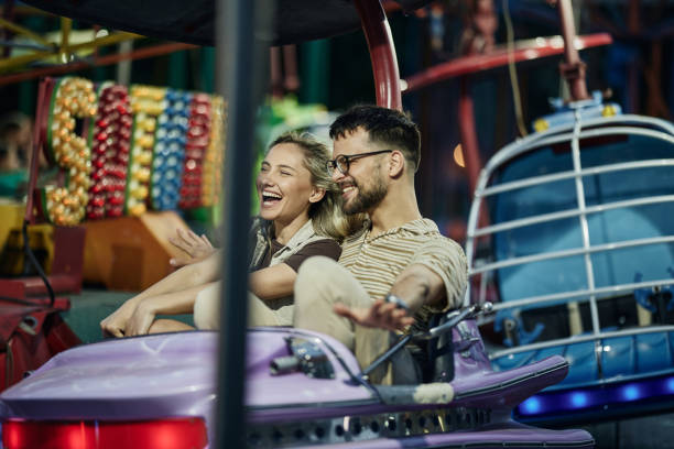 istock Young cheerful couple having a ride at amusement park. 2195420349