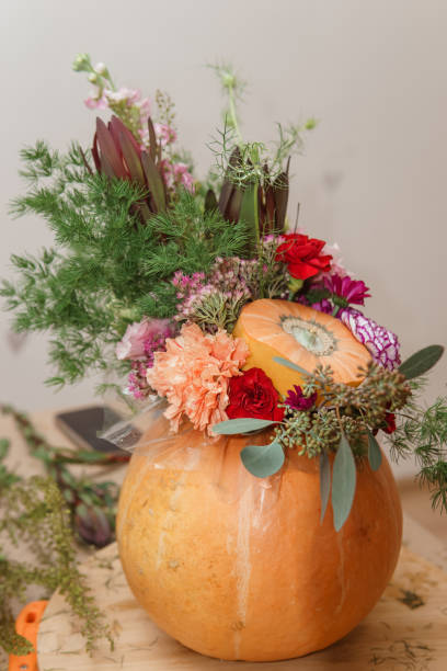istock Flower arrangement in a pumpkin, autumn interior decor. Creating handmade autumn decor. 2195420514
