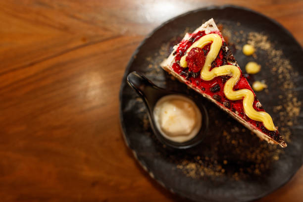 Delicious Slice of Layered Cake with Ice Cream on a Black Plate