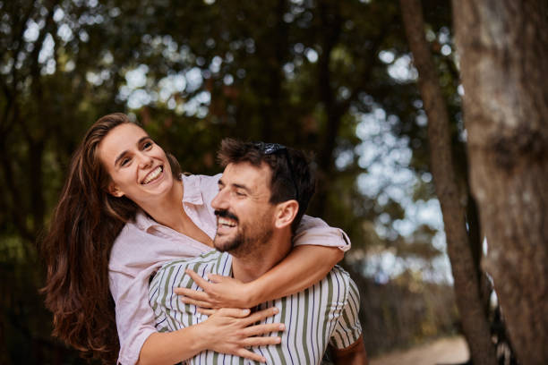 istock Cheerful couple having fun while piggybacking in nature. 2195421018