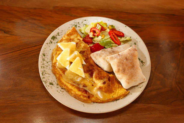 Omelet with spinach, mushrooms and chorizo cooked in old vintage pan served with three slices of bread