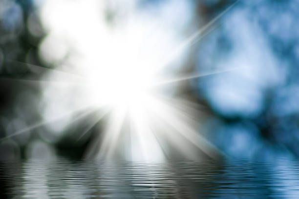 Bright sunlight filters through soft clouds, casting shimmering reflections on calm water. This peaceful moment captures the essence of nature waking at dawn, inspiring tranquility and wonder.