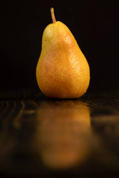 one fresh red pear with yellow color on the table, closeup of a pear