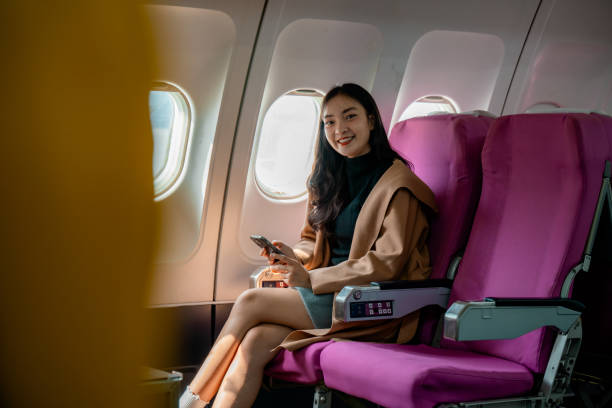 istock Traveler checking smartphone while seated by aircraft window during international journey 2195424834