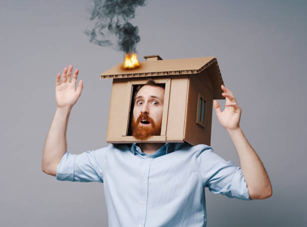 Homeowner with his head inside a burning cardboard house