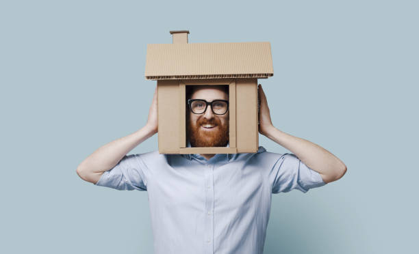 istock Man with head inside a cardboard house 2195427322