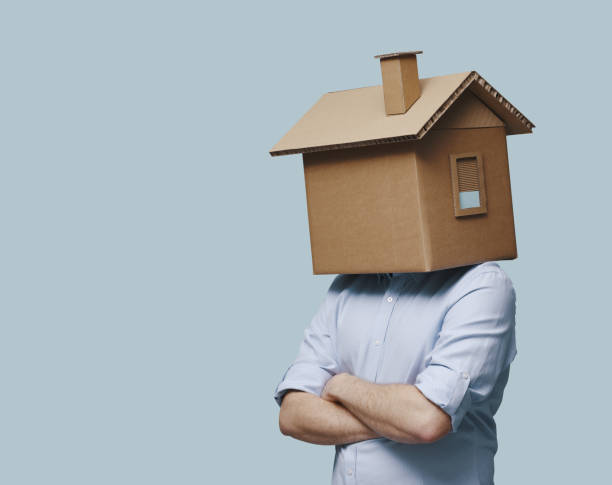 istock Pensive man with head inside a cardboard house 2195427780