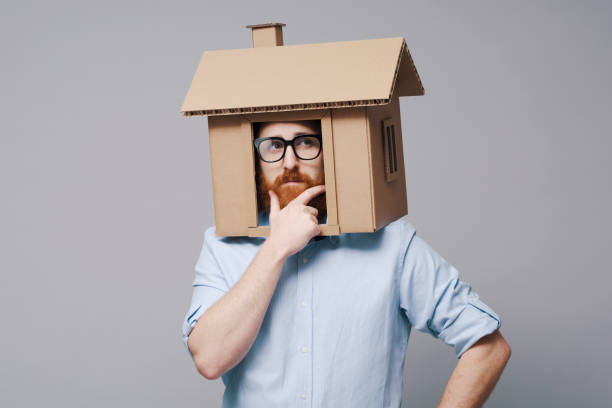 istock Pensive man with head inside a cardboard house 2195427832