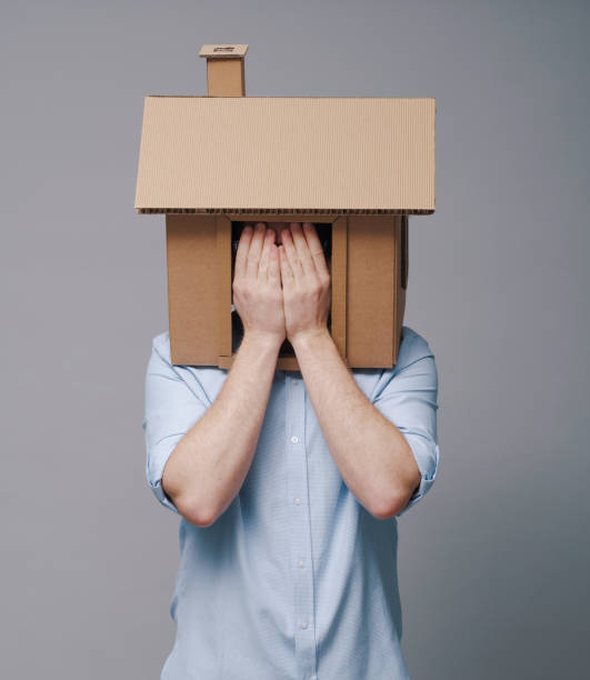 istock Desperate homeowner with cardboard house on his head 2195428040