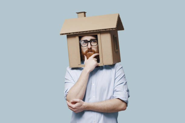 istock Pensive man with head inside a cardboard house 2195428152