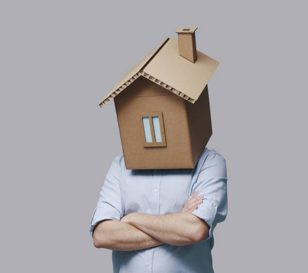 istock Pensive man with head inside a cardboard house 2195428952