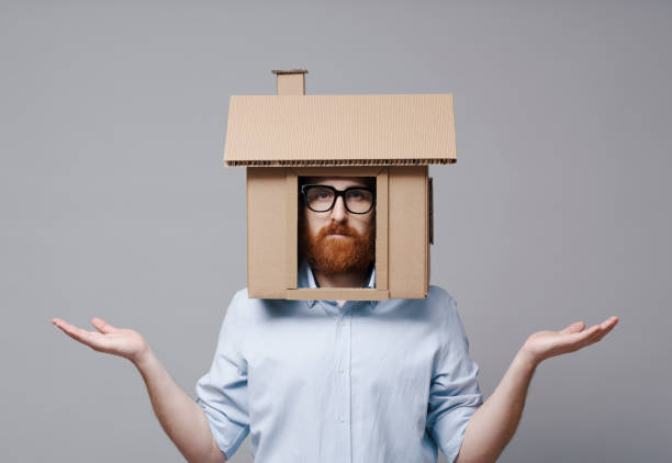 istock Desperate homeowner with cardboard house on his head 2195429003