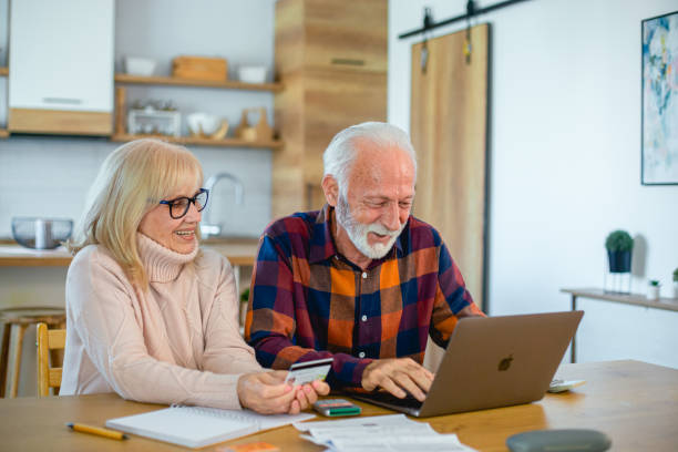 istock Happy senior couple using laptop while planning their home budget 2195429346