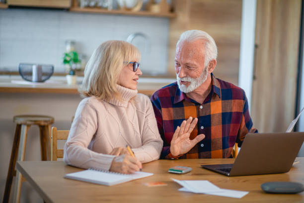istock Happy senior couple using laptop while planning their home budget 2195429409