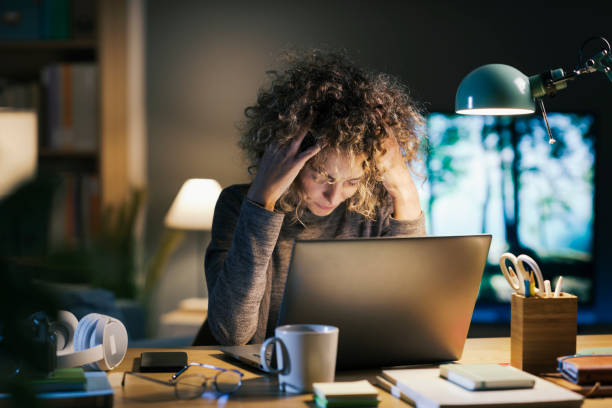 istock Woman working late and having an headache 2195429414