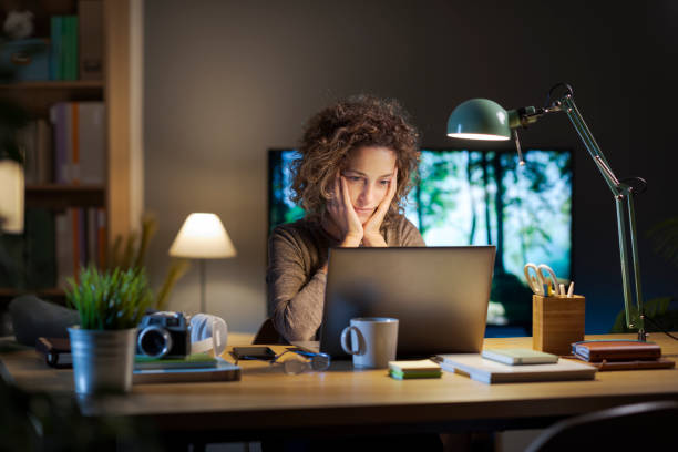 istock Woman getting online using her laptop late at night 2195429820