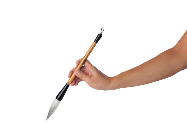 istock Hand holding traditional writing brush isolated on white background 2195430784