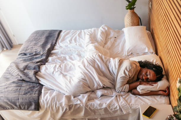 istock Serene black woman sleeping peacefully in comfortable bed at home 2195431475