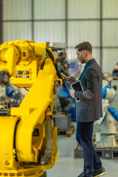 istock Factory Owner and Manager Inspecting Robotic Arm 2195437569