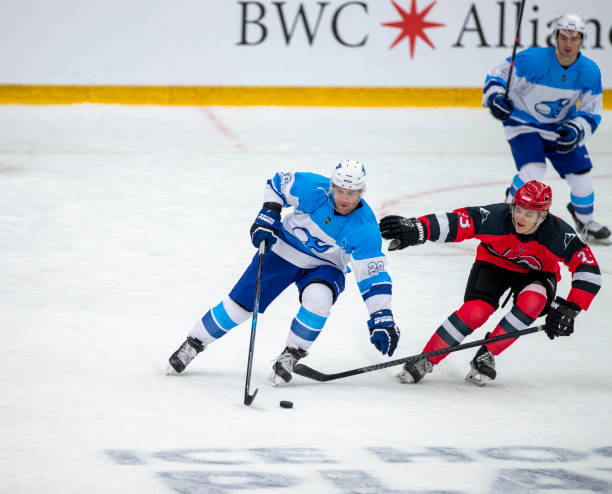 istock Professional Ice Hockey Players Compete for Puck Control During Game Action 2195438700