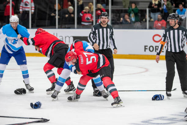 istock Professional Ice Hockey Players Battle During Face-off with Referees Watching 2195438726
