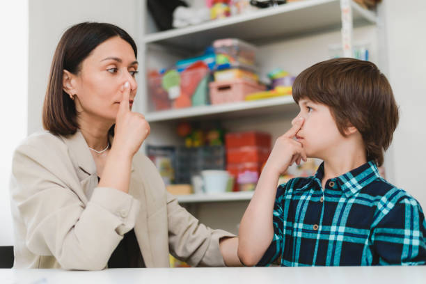 istock Cute preschool child is engaged in speech therapist office and correcting his speech 2195439895