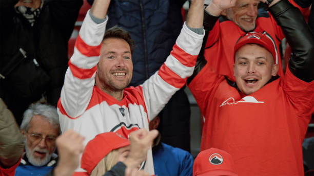 istock Diverse Crowd Cheering Passionately at Ice Hockey Game 2195442126