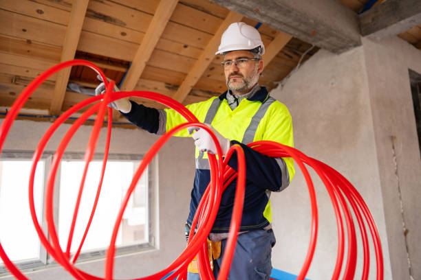 istock Worker Handling Red Tubes for Floor Heating in Building Construction Site 2195443780