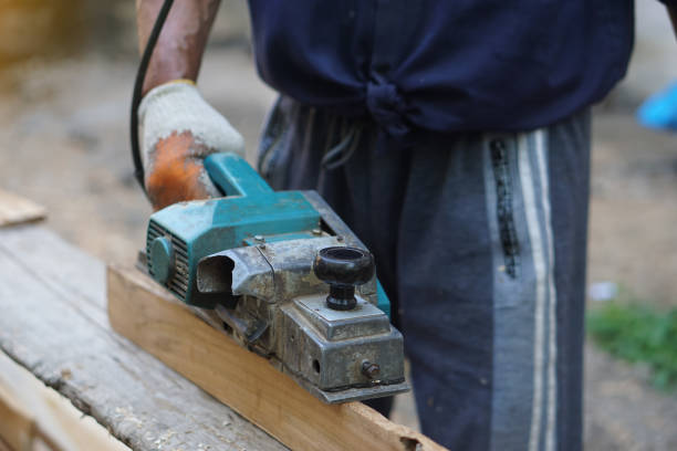 istock Closeup carpenter using electric planer with wooden plank in carpentry worksite. Concept, tool or equipment for construction work. Using with careful and skillful for safety. 2195444295