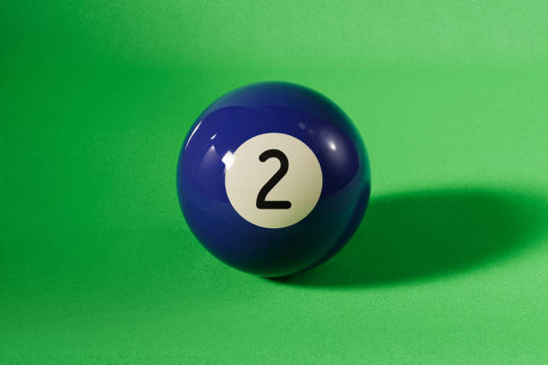Blue number 2 pool ball on green background. Horizontal composition with copy space.