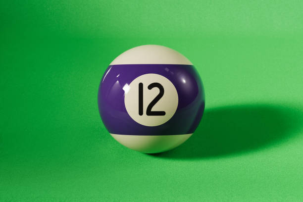 Purple number 12 pool ball on green background. Horizontal composition with copy space.