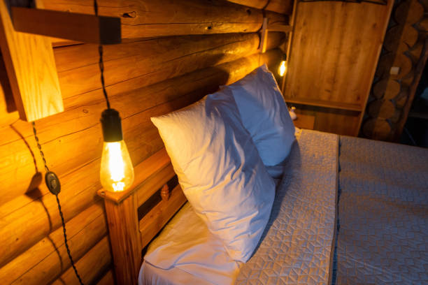 istock Cozy Log Cabin Bedroom with Warm Lighting 2195450680