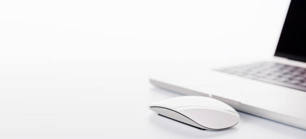 Closeup of an office table featuring a sleek laptop on a clean white surface with ample copy space, presented in high-key lighting for a minimalistic and professional vibe