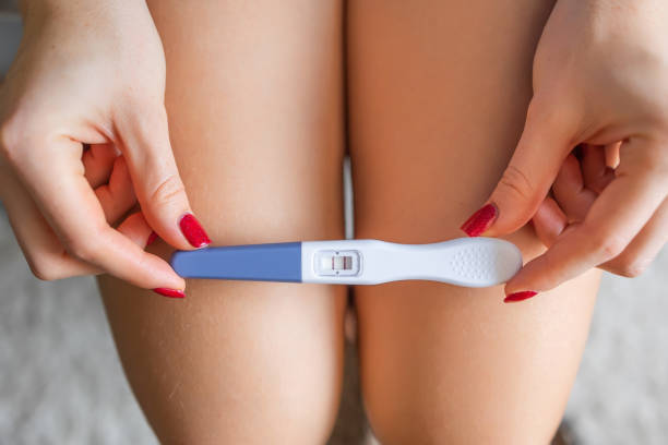 istock Close up positive pregnancy quick plastic test with two red stripes confirm that female is pregnant. New life, feminine health, happy changes and fertilization concept 2195452533