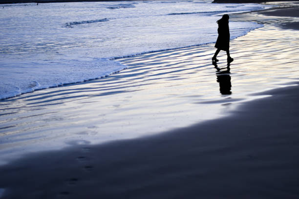 Walk slowly along the shining beach with the reflection of the setting sun