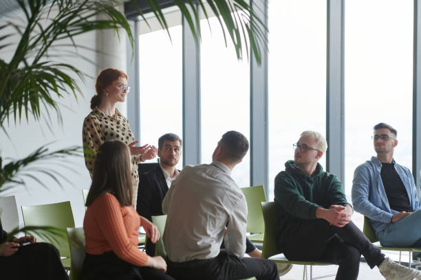 istock A diverse group of business professionals sits attentively in a modern office, actively participating in a training session led by an instructor, focusing on the latest technological advancements in the business world. 2195455977