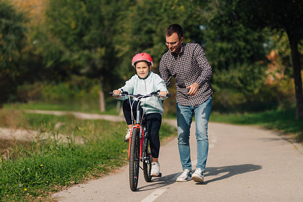 Family with bikes preparing for ride outside modern house garage on sunny day