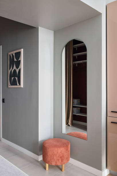 istock Stylish and inviting interior corner featuring a decorative mirror and a contemporary stool 2195459631