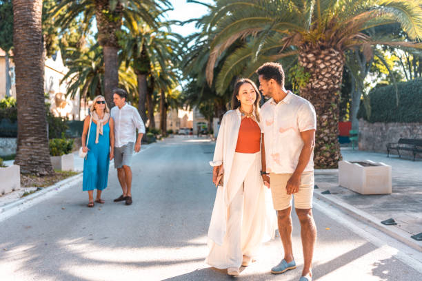 istock Diverse Couples Stroll in Coastal Town Promenade 2195461553