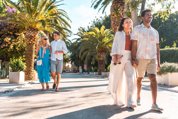 istock Diverse Couples Strolling Coastal Promenade 2195461562