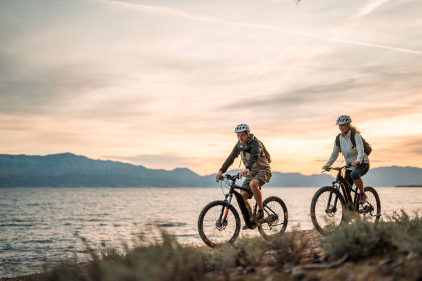istock Active Senior Couple with E-Bikes Enjoying Seaside Sunrise 2195462111